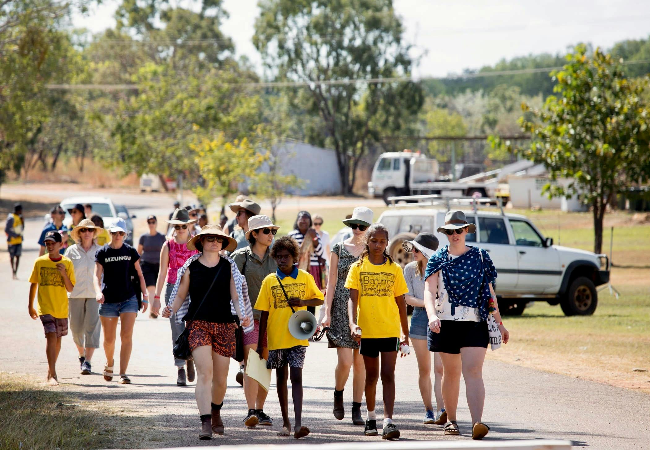 Children in yellow leading tours of the community area