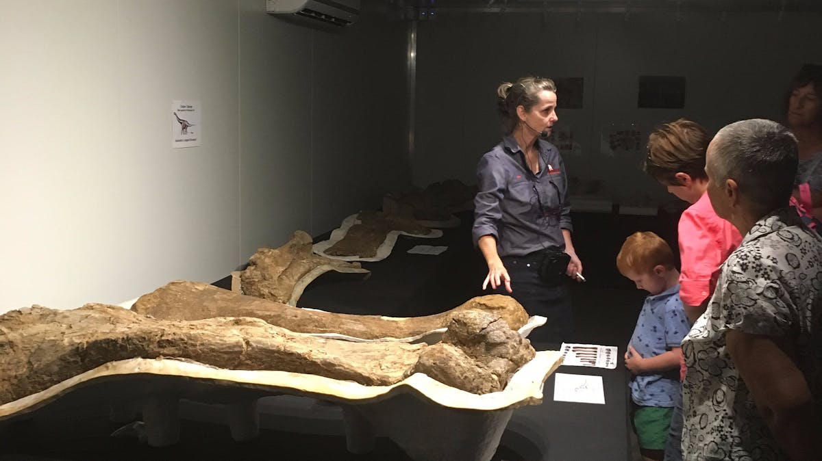 Tour group standing in front of tour guide Robyn Mackenzie as she  explains the holotype room