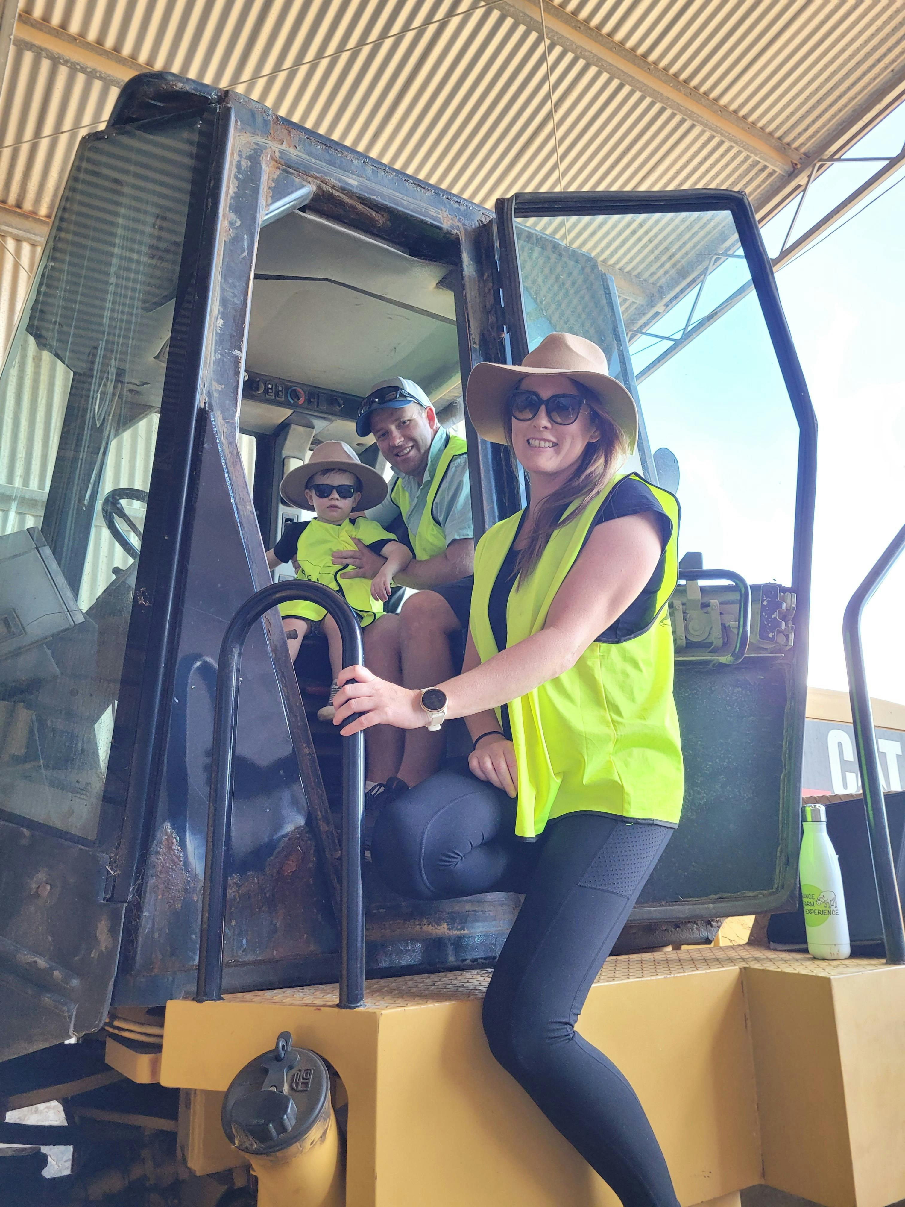 Family in cab of front end loader