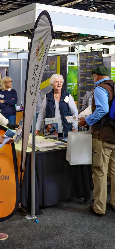 People standing at COTA ACT Expo stall