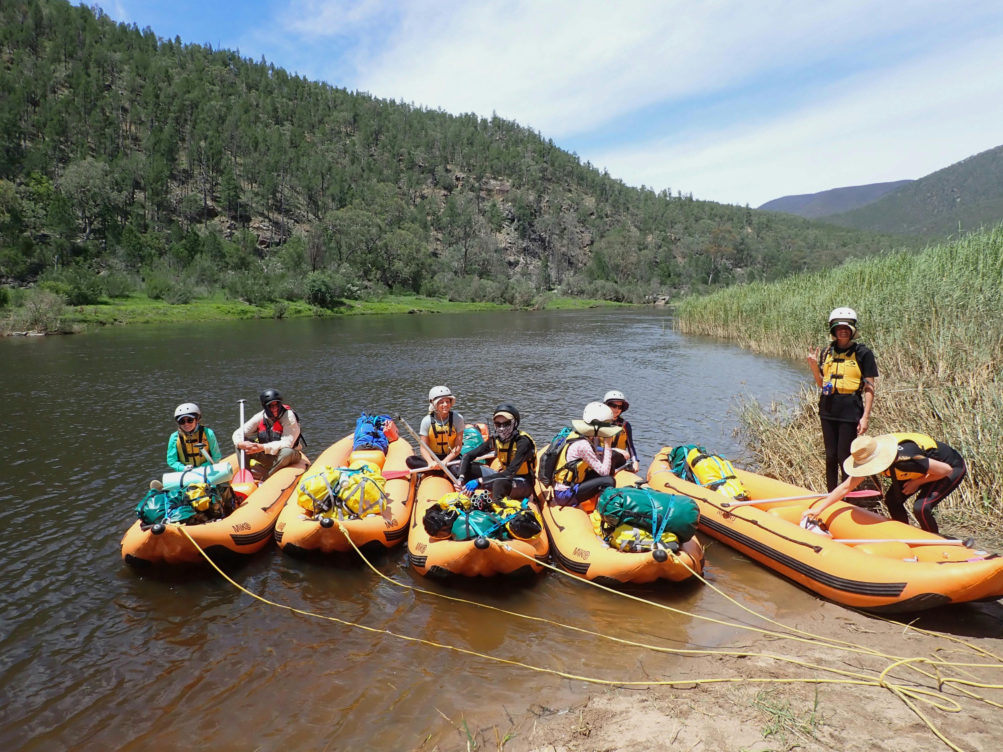 people sitting in rafts beside the Snowy rRiver on the  snowy river whitewater rafting tour.