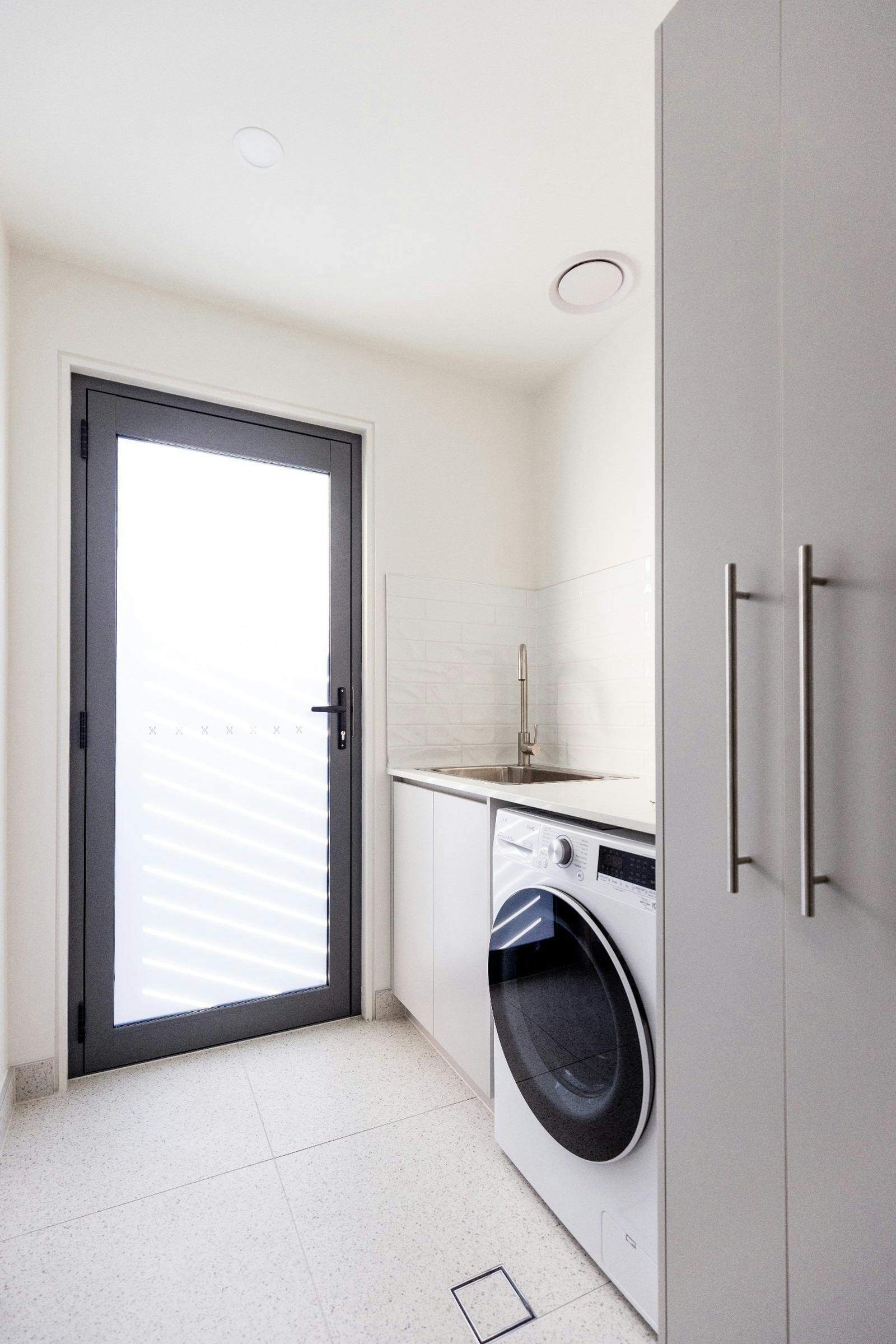 Convenient full laundry with washer/dryer, sink and storage space, ideal for longer stays