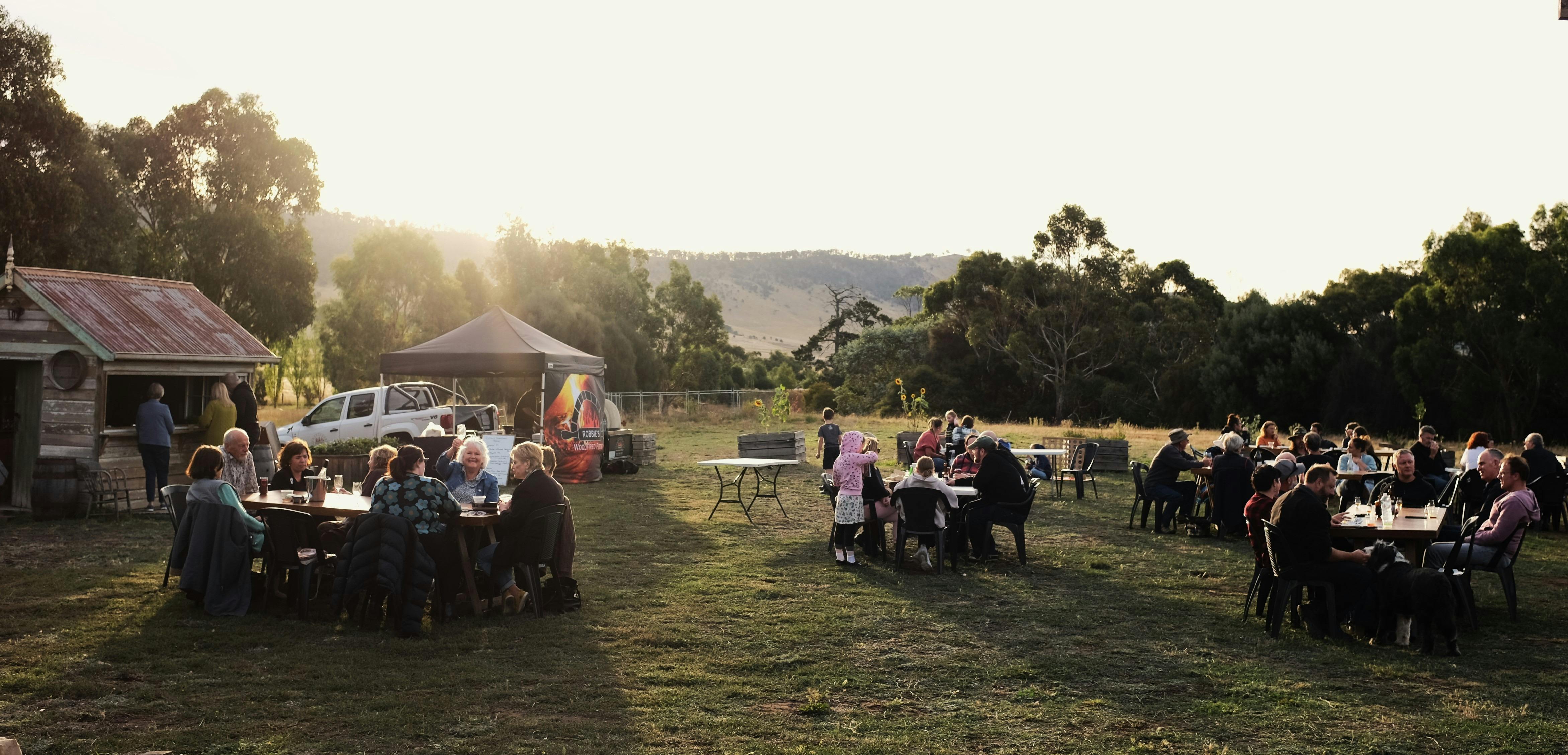 Image of people at tables enjoying drinks and food outside at Killara Distillery