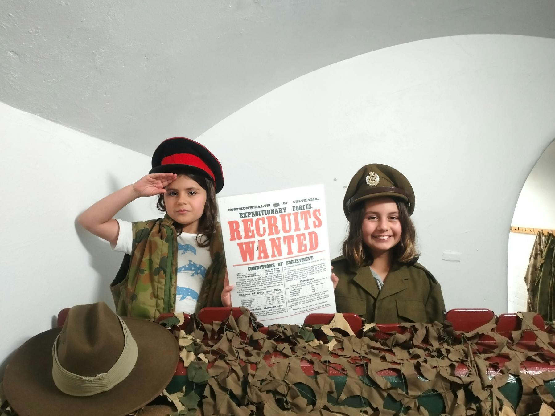 Childrens in Dress Ups saluting and smiling with a sign