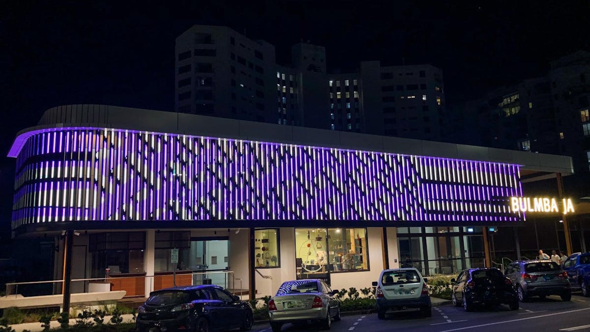 LED digital artwork facade in purple stripes by Aboriginal artist