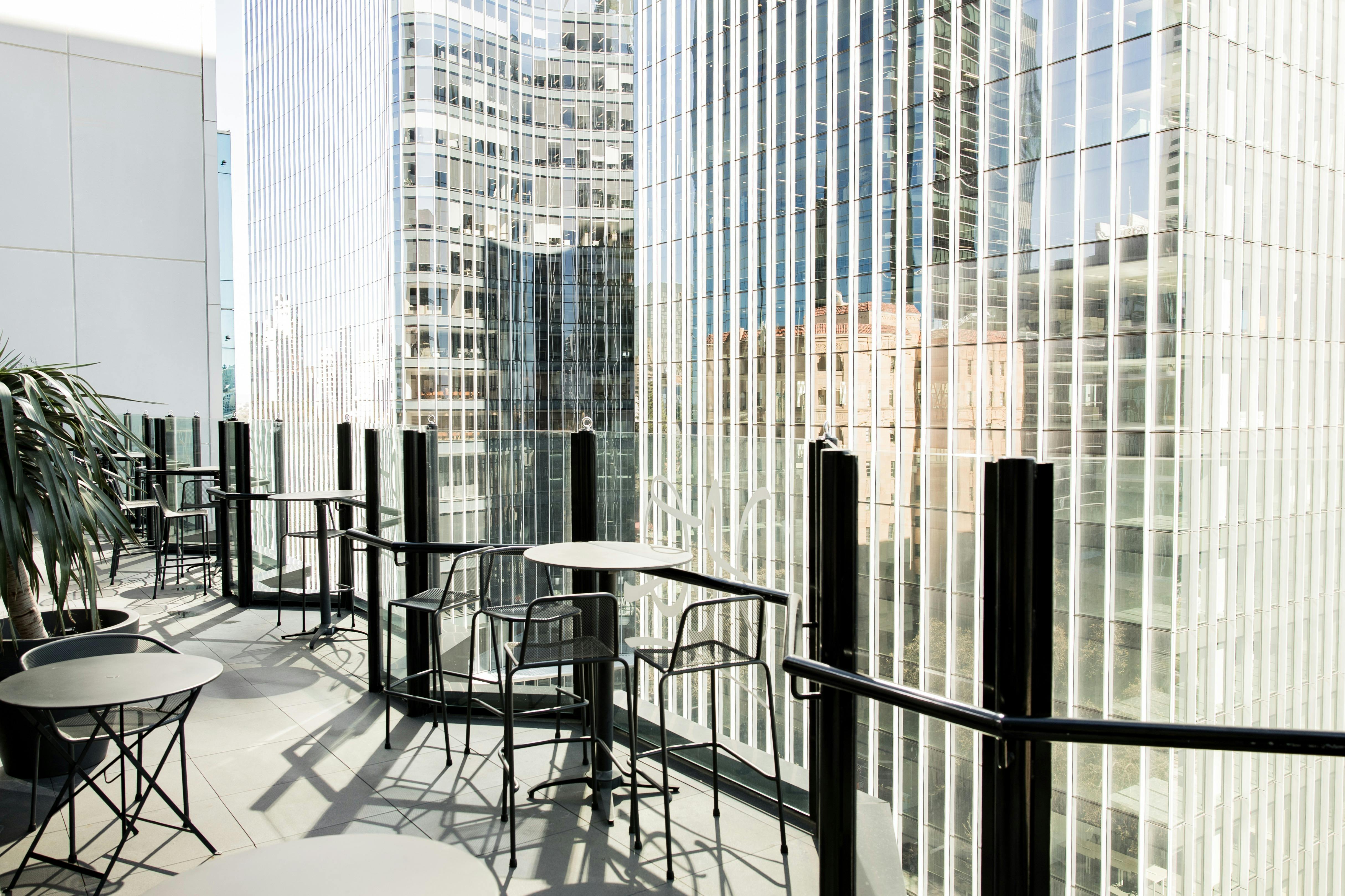 Rooftop terrace with outdoor seating  overlooking the Elizabeth Quay skyline.