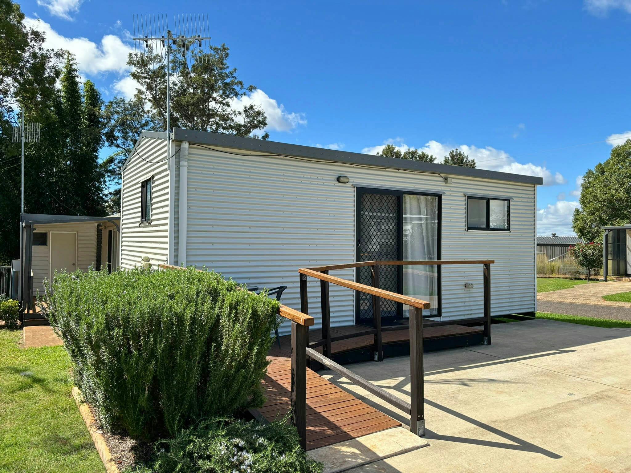 Deluxe Wheelchair Friendly Cabin exterior with timber ramp access at Yarraman Caravan Park & Cabins Deluxe Wheelchair Friendly Cabin exterior with timber ramp access at Yarraman Caravan Park & Cabins