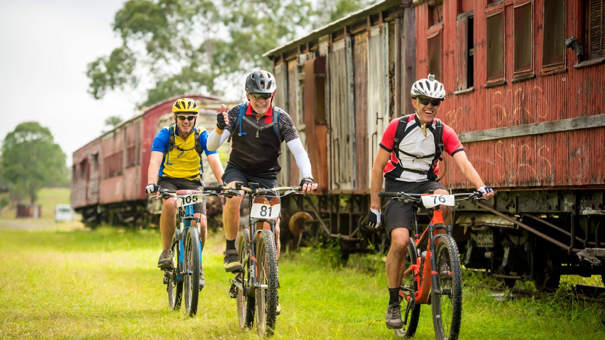 Bike riders riding along the BVRT and past Linville Station Carriages