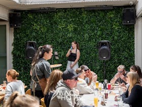 Guests dining in the courtyard while local singer, Ella Williams performs on a small stage