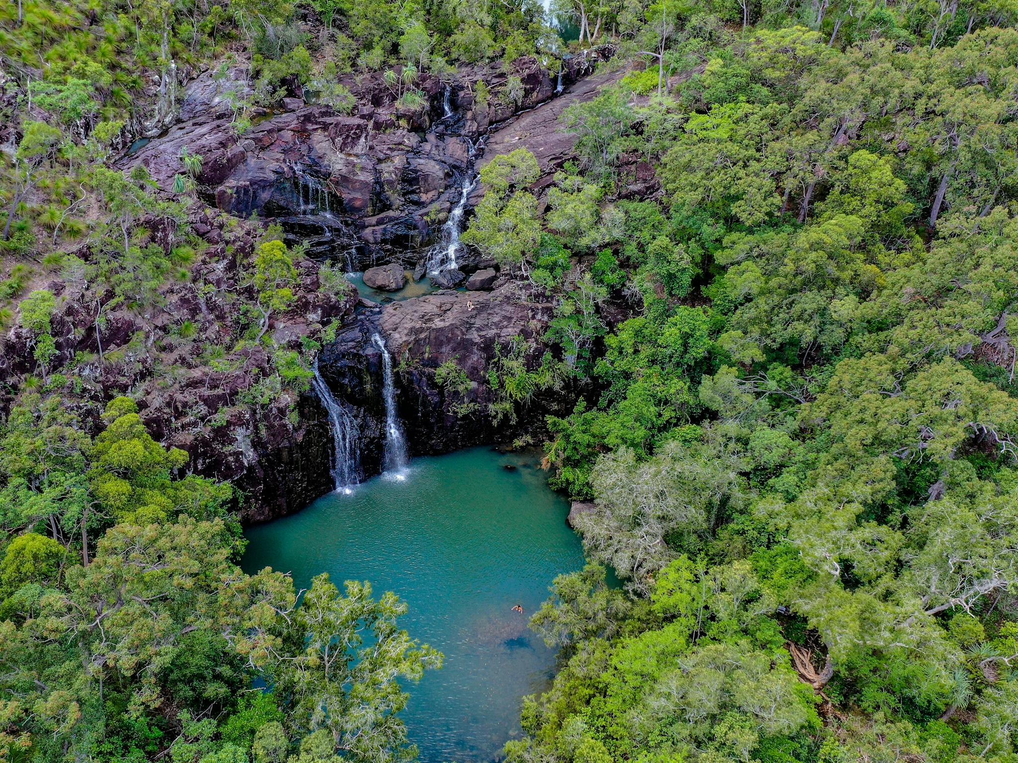 Aerial view of the cedar creek falls and rockpools surrounded by lush greenery