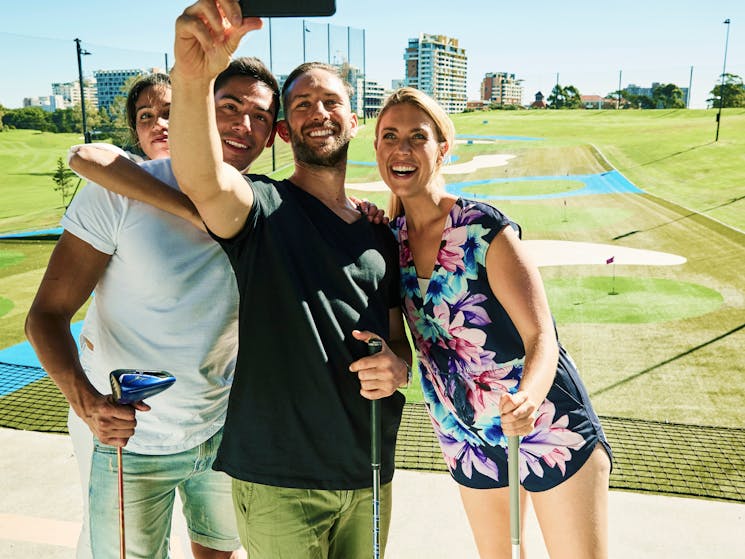 Four people taking a selfie at the Driving Range