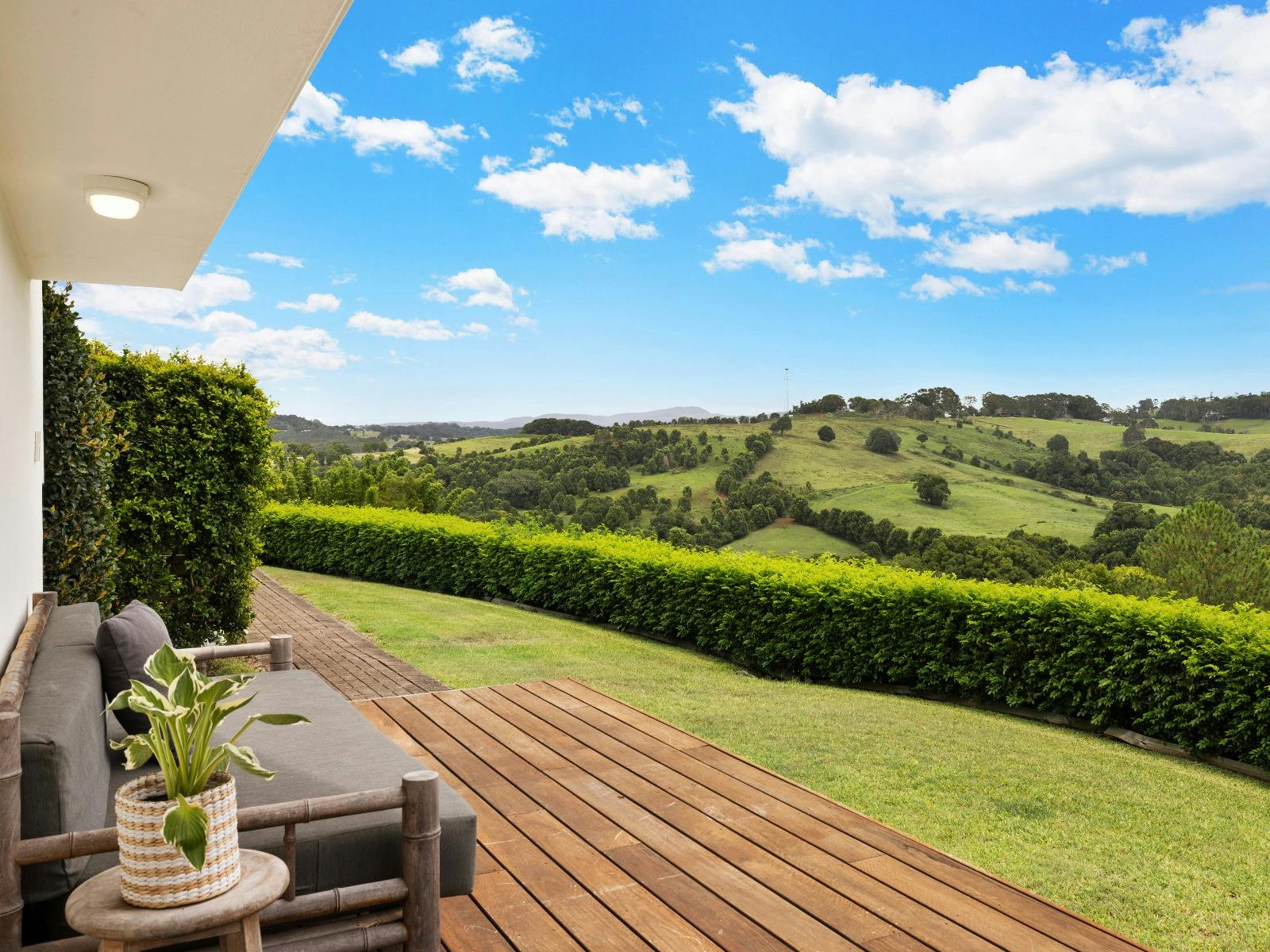 Private deck and garden at Byron's Brae overlooking rolling green hills and the peaceful Byron Bay h