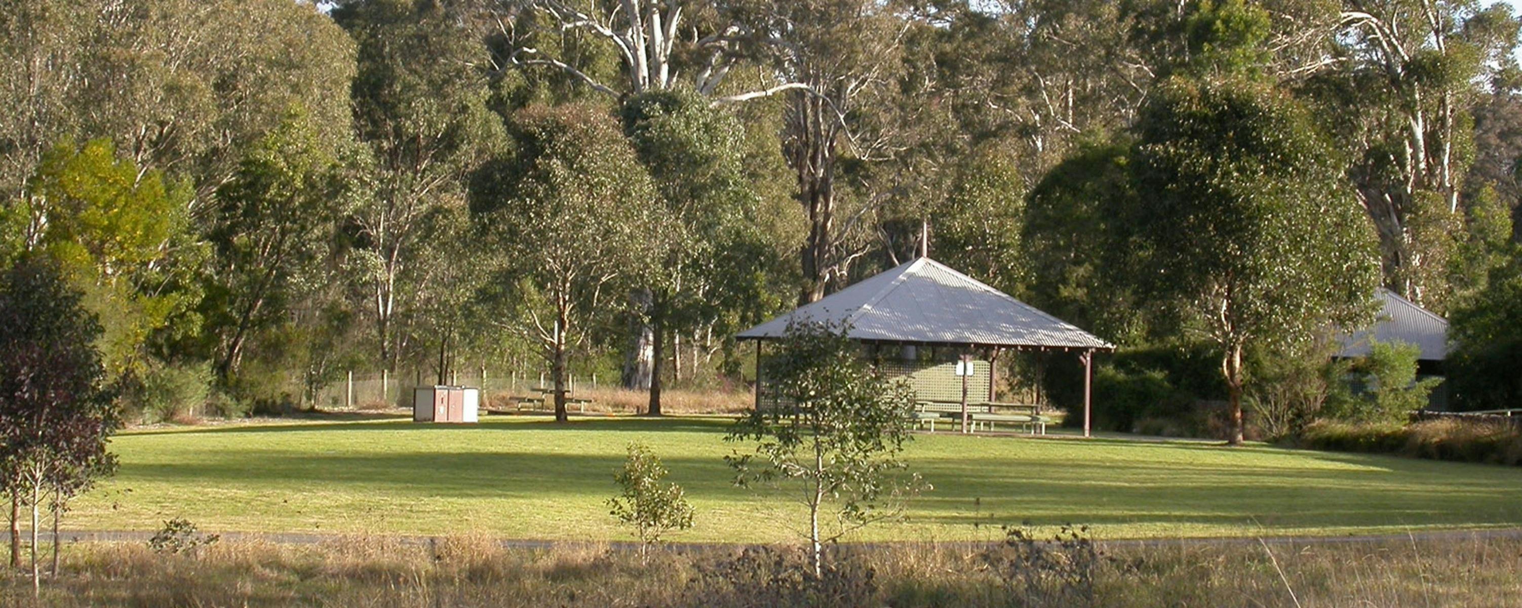 Picnic gazebo surrounded by trees on a grassed area