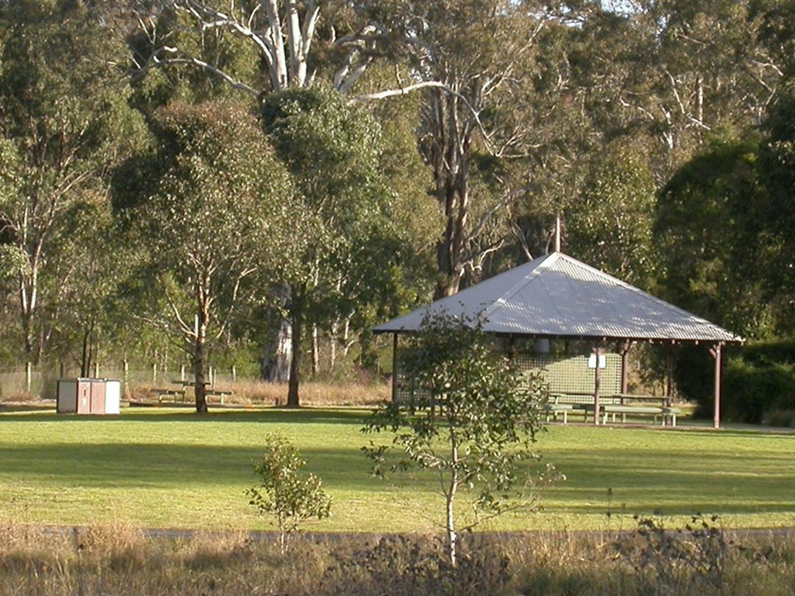 Picnic gazebo surrounded by trees on a grassed area