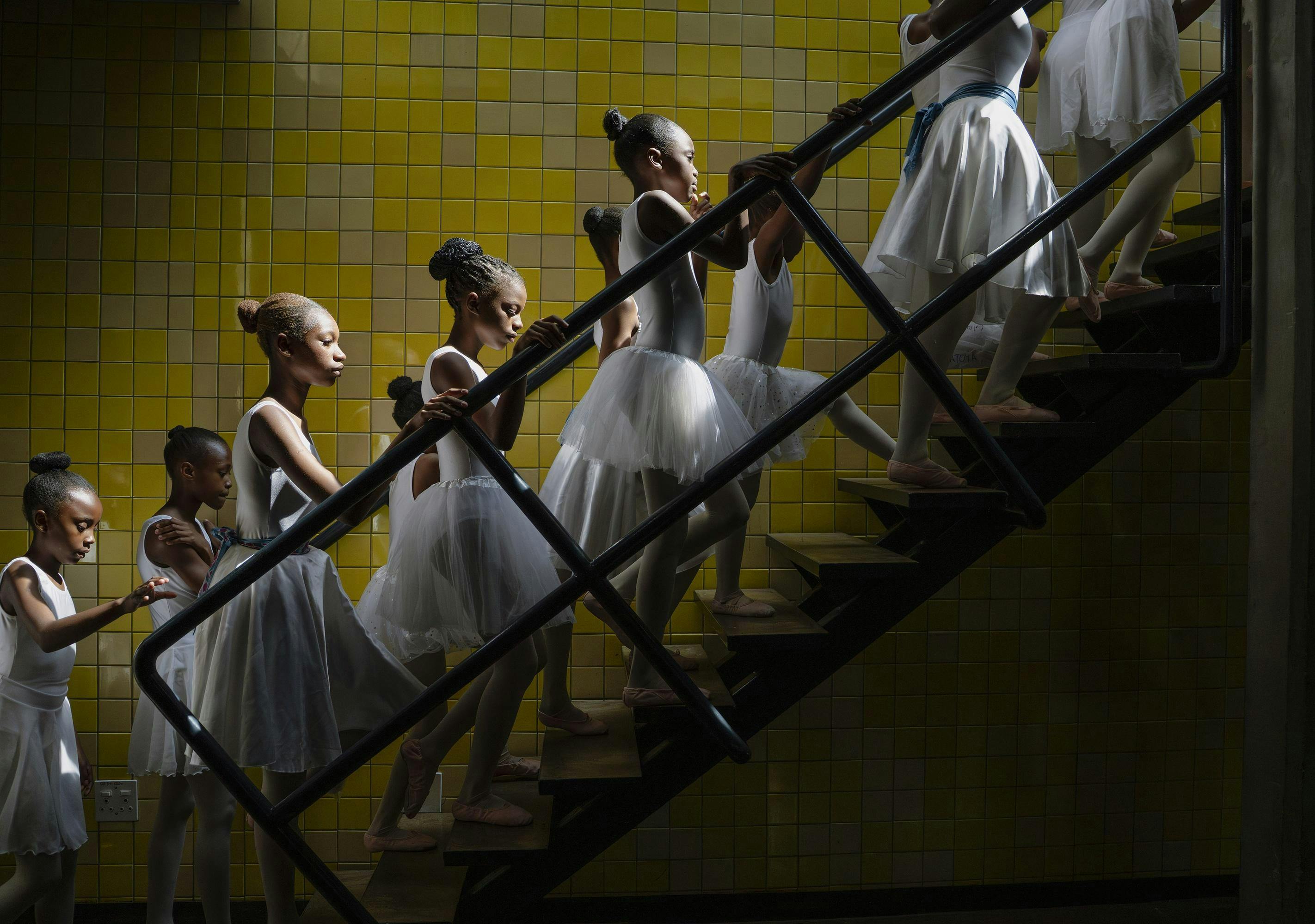 Young ballerinas walking up a staircase