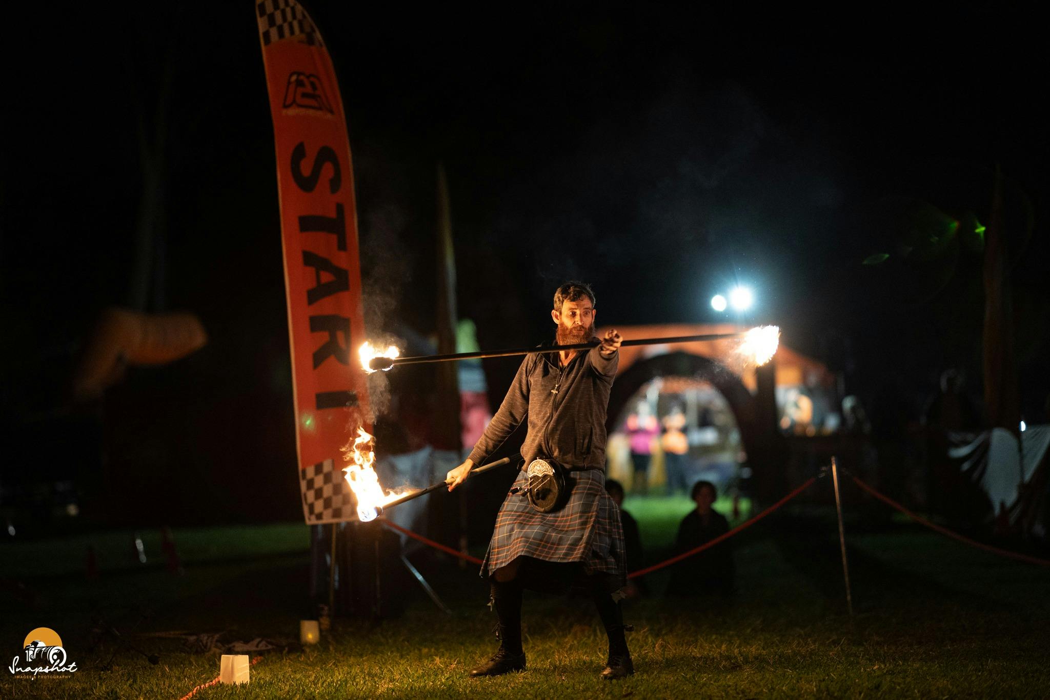 Bag pipe player with twirling fire sticks