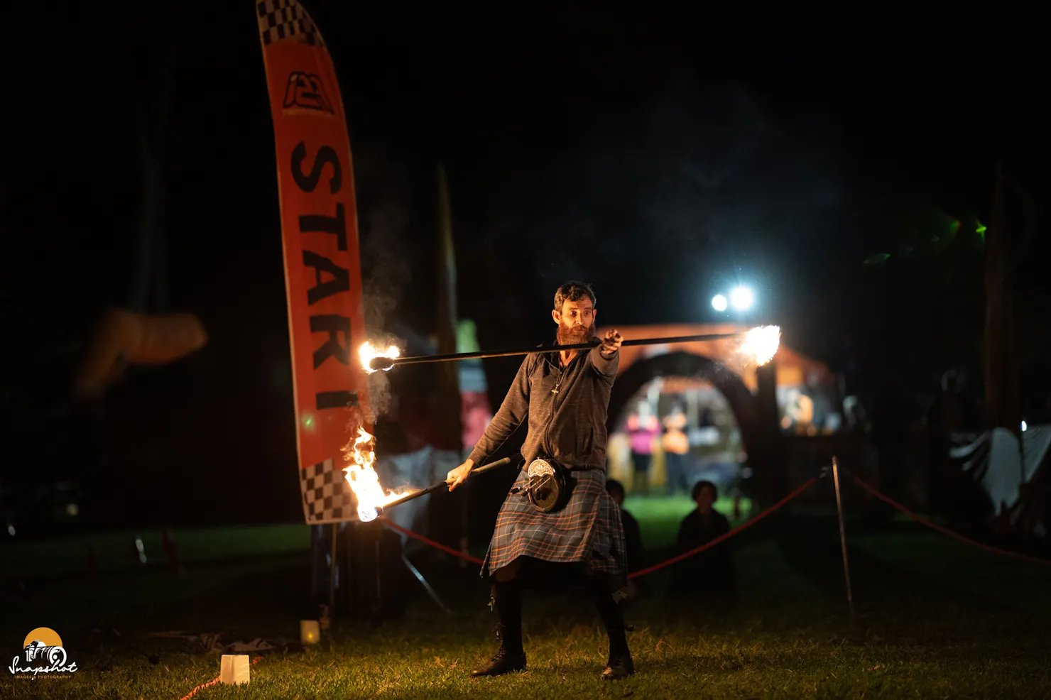 Bag pipe player with twirling fire sticks