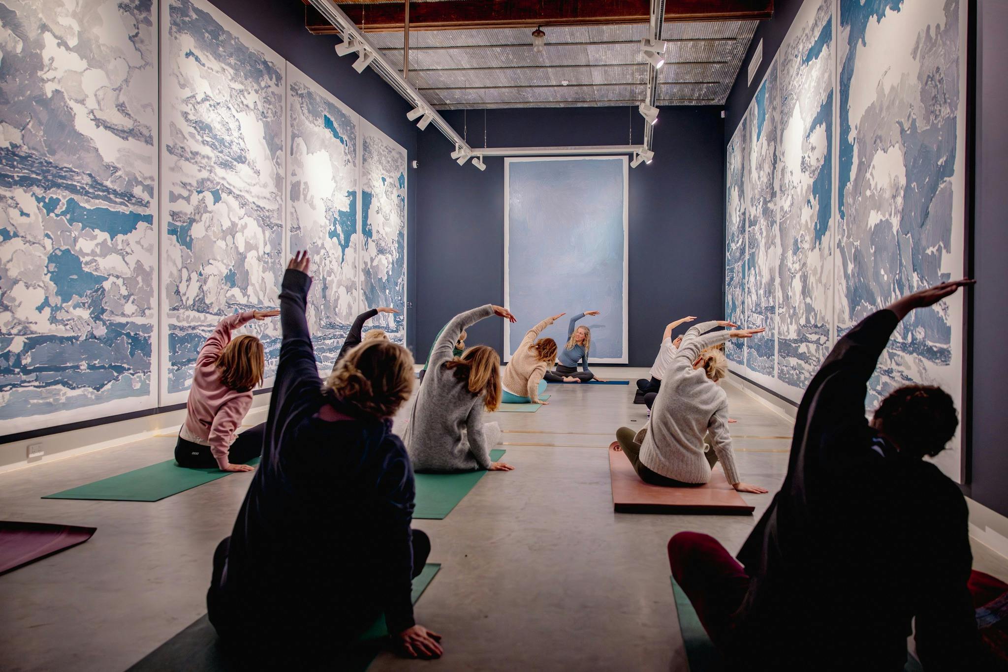 People doing yoga in an art gallery