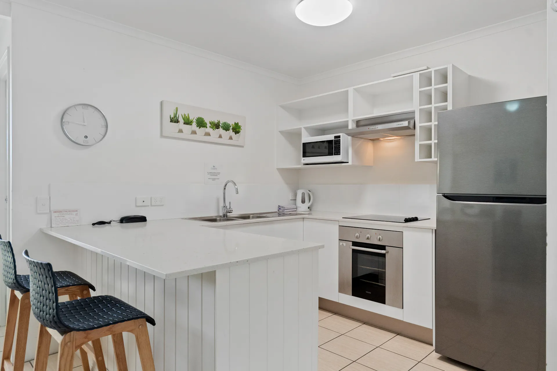 Kitchen with fridge, sink, oven and benchtops