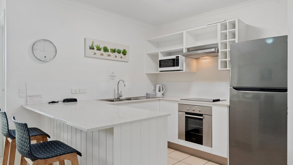 Kitchen with fridge, sink, oven and benchtops
