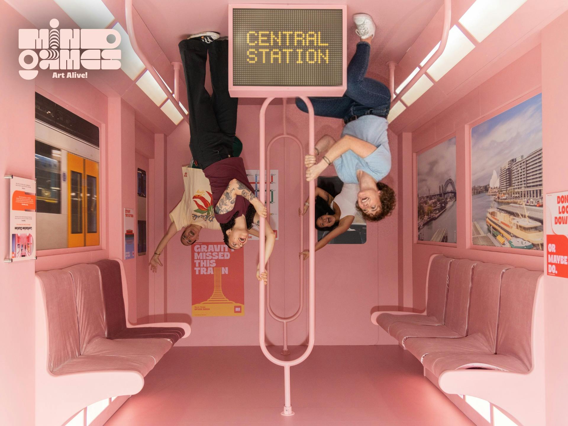 Visitors appear to hang upside down inside the Upside Down Train exhibit, an interactive illusion in