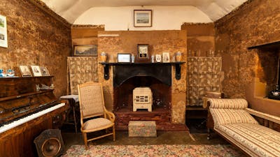 Fireplace in Mugga-Mugga cottage with historical photographs and objects