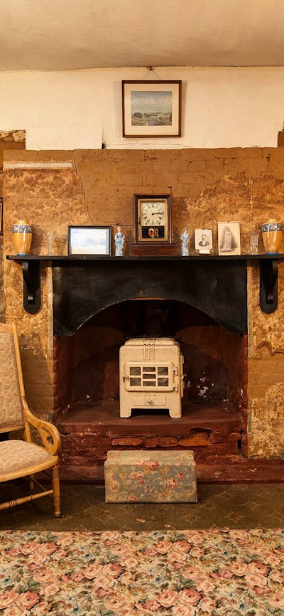 Fireplace in Mugga-Mugga cottage with historical photographs and objects