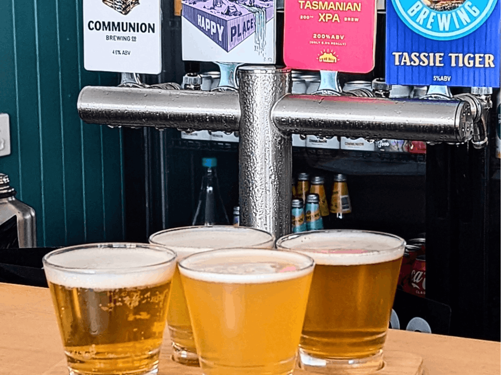 4 beer fonts with decals showing various Tasmanian beers and a tasting paddle with 4 beers