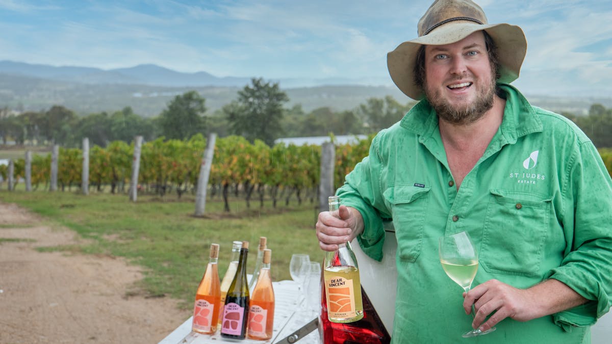 Adam the owner of Dear Vincent Pours a glass of wine for the wine tasting on the back of a ute