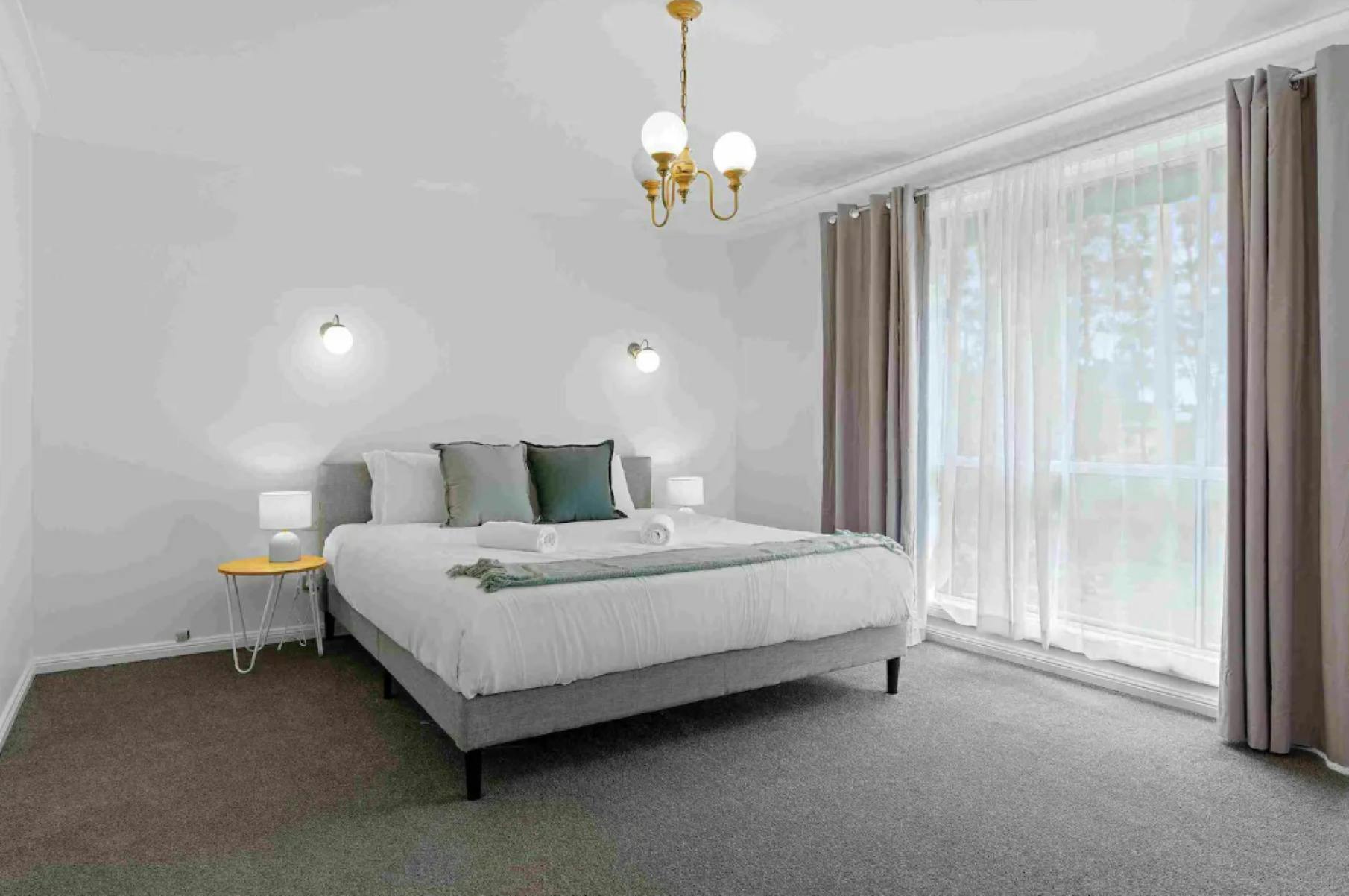 킹 사이즈 침대 대형 창문 및 빈티지 펜던트 조명이 있는 마스터 침실