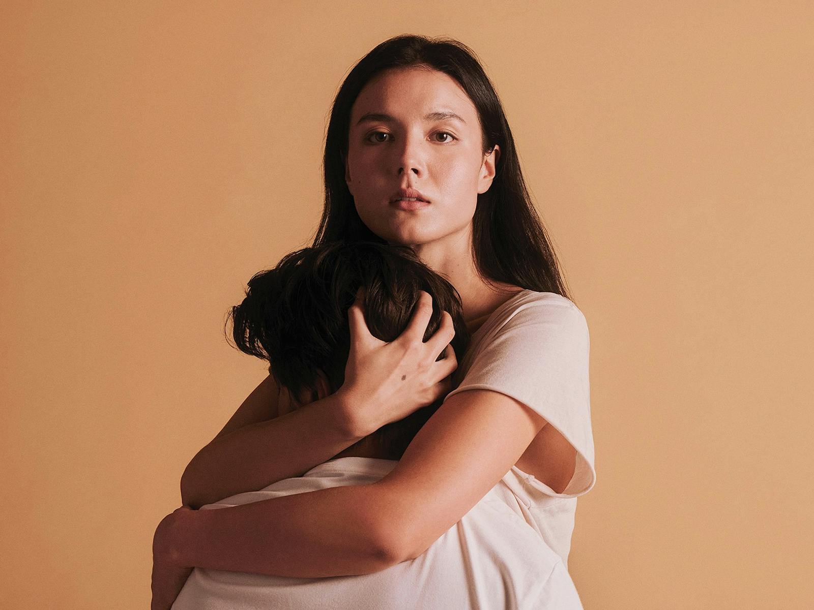 A woman holds a man in her arms
