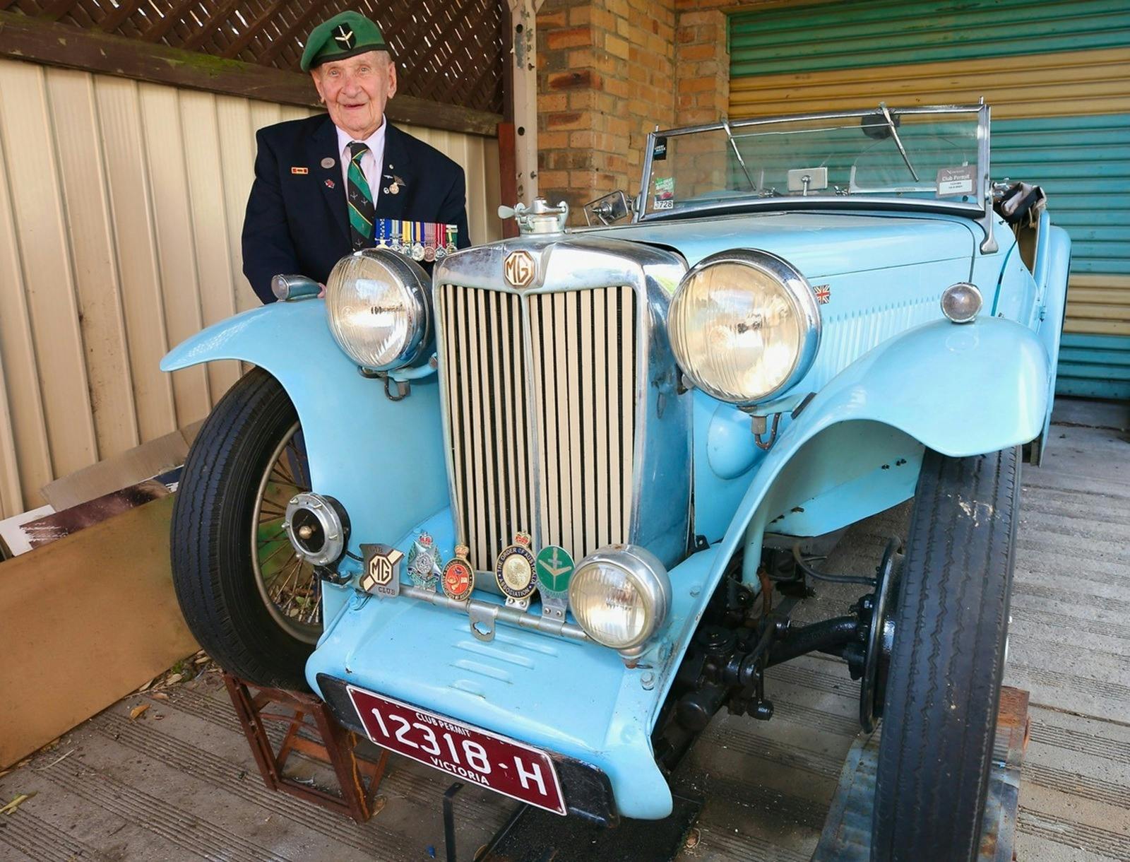 Don Bergman standing beside a vintage vehicle