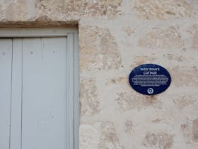 Historic Patsy Ryanu2019s Cottage plaque on limestone wall at 1856 Cottage in Robe South Australia
