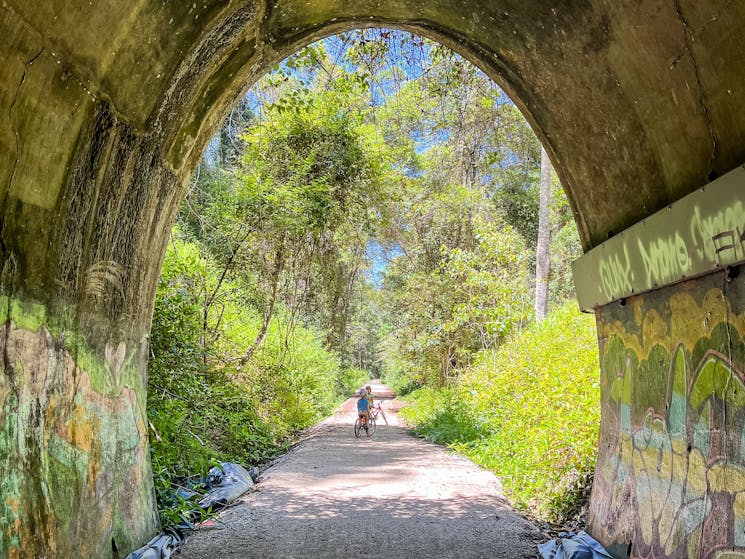 Lookout out of the end of the tunnel to the trail and a cyclist on the Northern Rivers Rail Trail