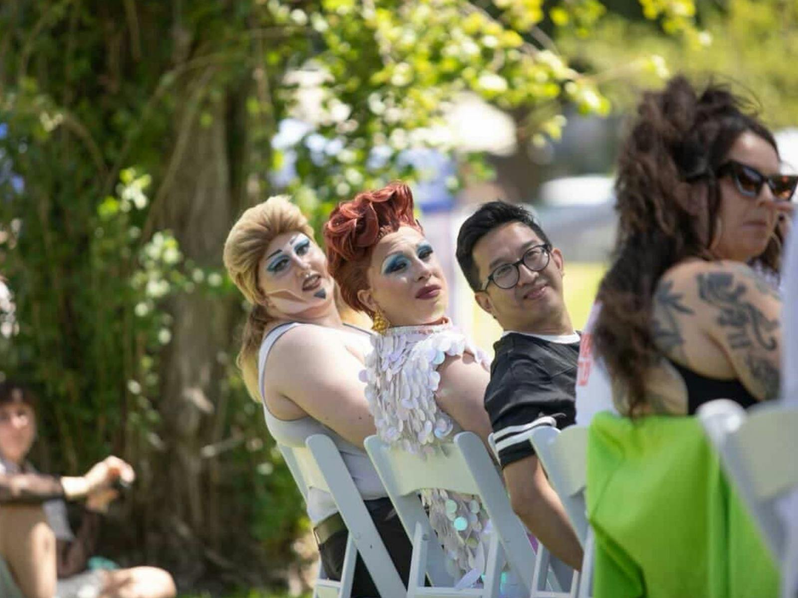 Two drag performers sit with local community