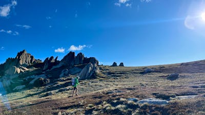 A hiker walking up a slope off track.
