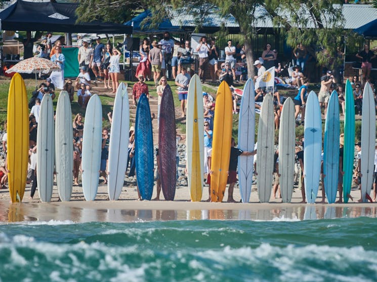 Surfers compete on old longboards and attempt to catch the furtherest wave marked by our judge