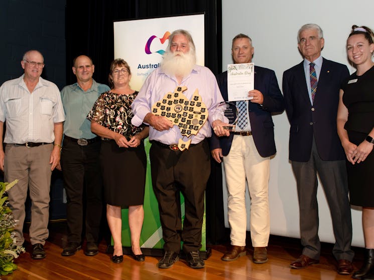 7 people with flowers and awards certificate