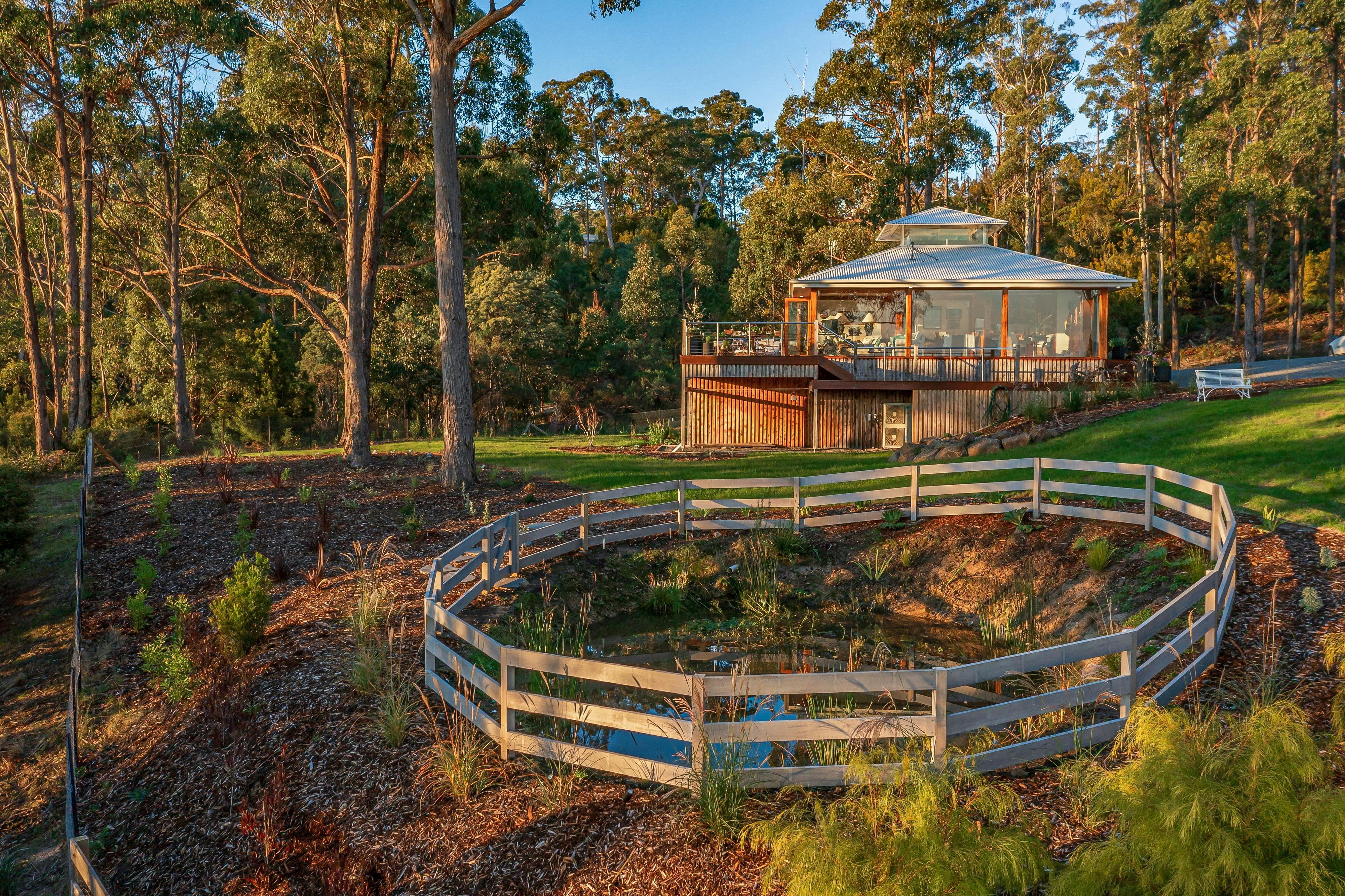 An golden hour photo of the Huon River Hideaway bushland property with the house in the background
