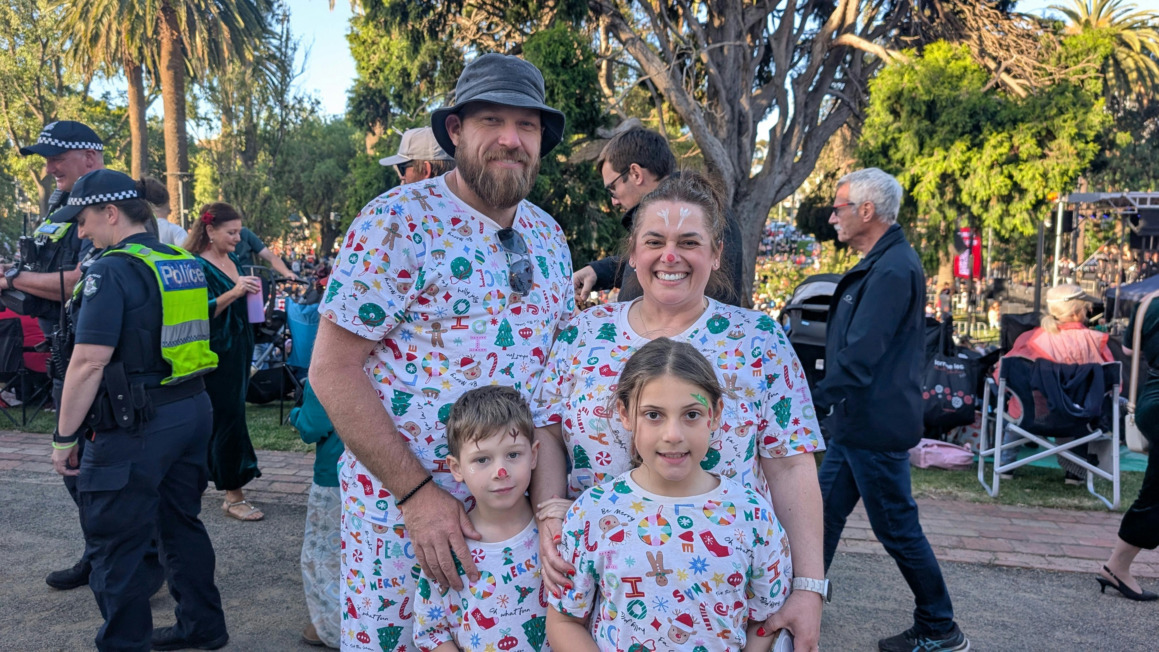 two adults and two children in christmas theme clothing at Carols By Candlelight