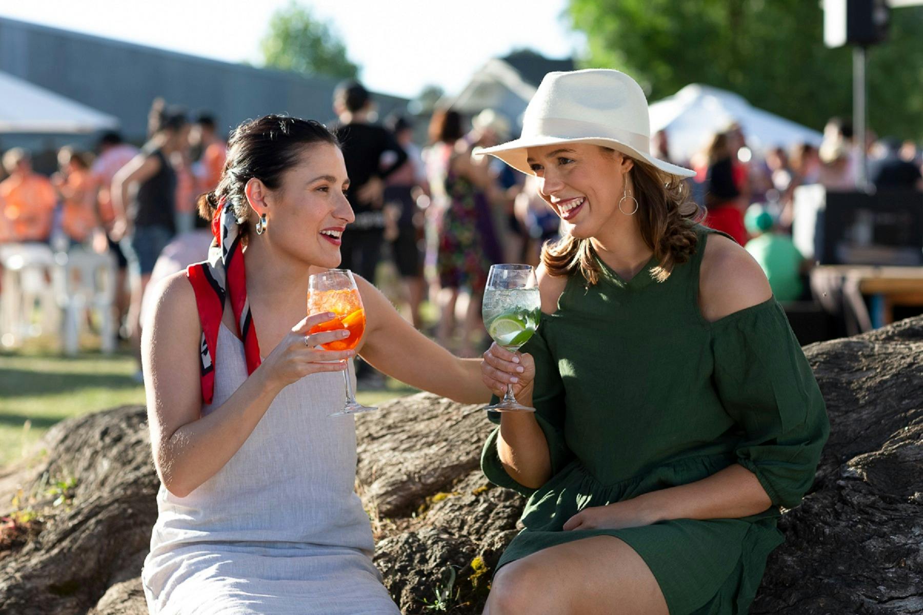 Dal Zotto Wines Easter two women enjoying a cocktail by the gumtree at a festival