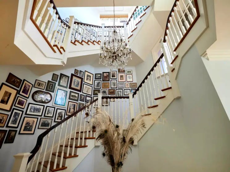 Stunning two-storey spiral staircase adorned with numerous frames adorned, adding to its charm