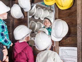 Young children choosing their helmets before a tour.
