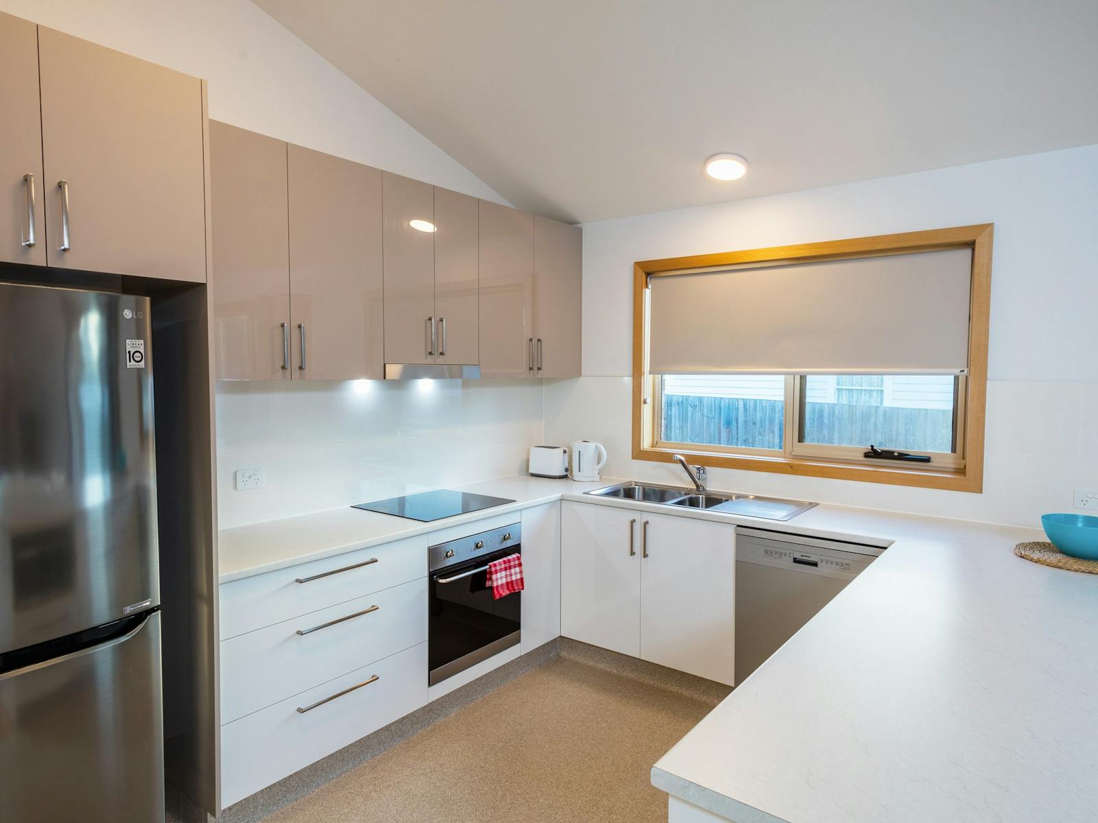 The kitchen has a fridge and freezer, glass-top hob, oven, dishwasher and double sink.