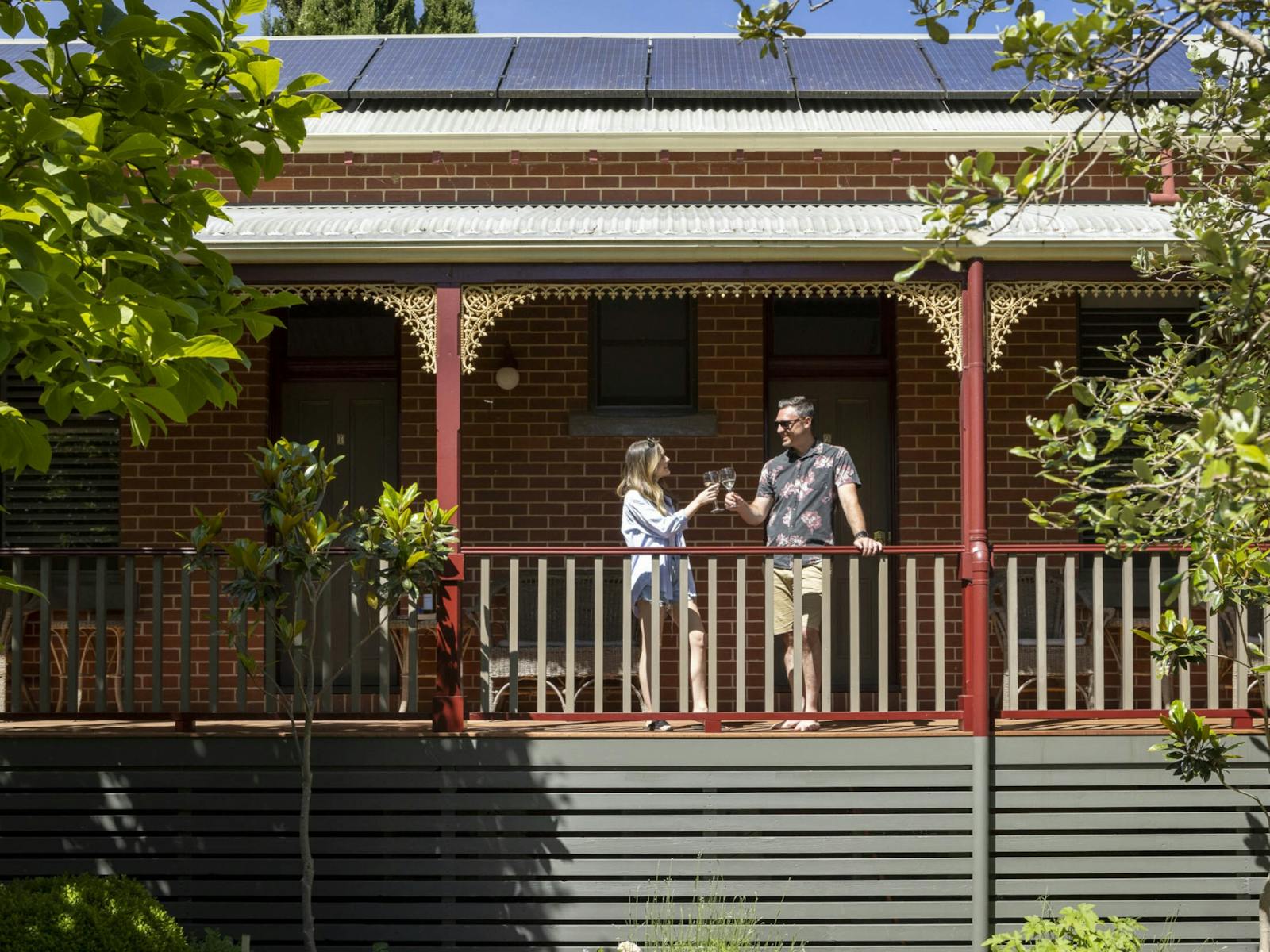 couple standing at the balcony and holding glasses of wine at The Brewer's House
