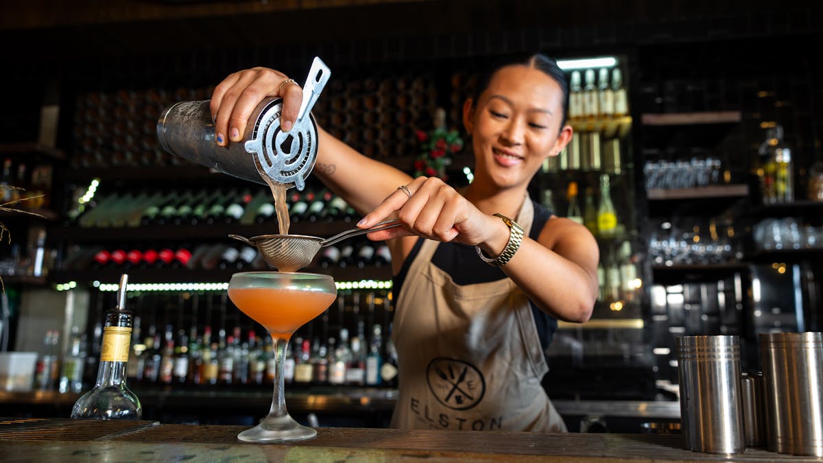 Bartender straining cockatil into glass at Soul Boardwalk