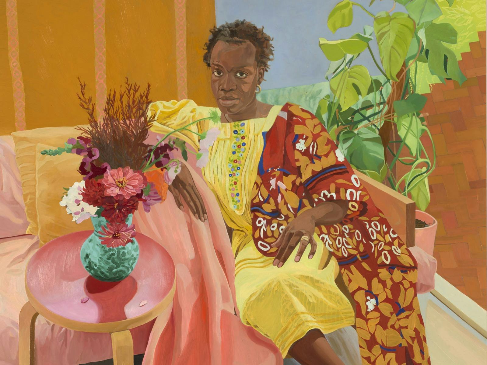 Seated figure in yellow and patterned robes beside flowers, pink furnishings and lush green plants.