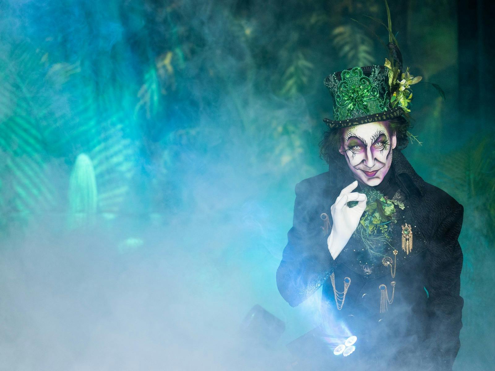 A character performers in a top hat amidst smokey haze