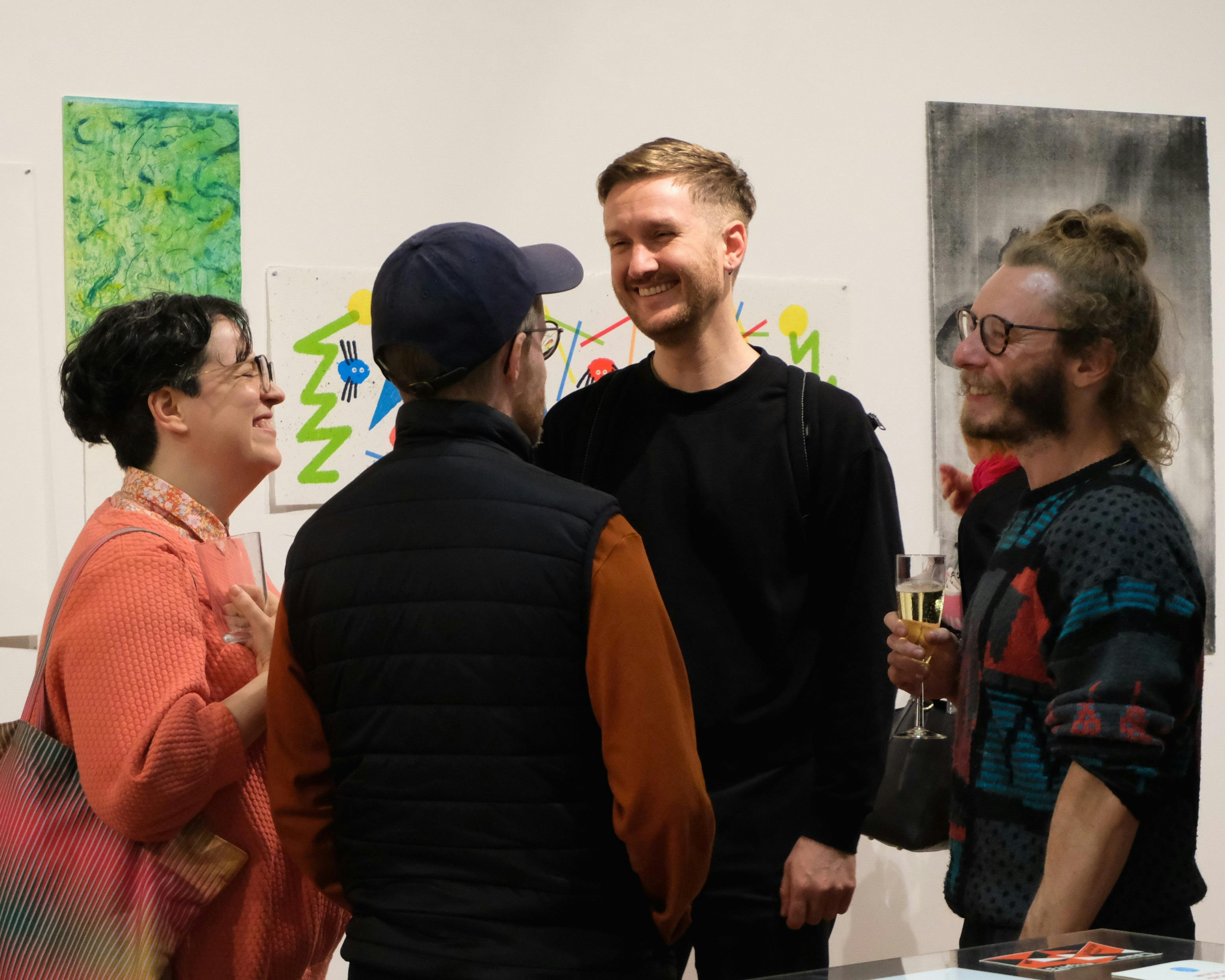 Four people talk in a gallery