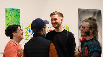 Four people talk in a gallery